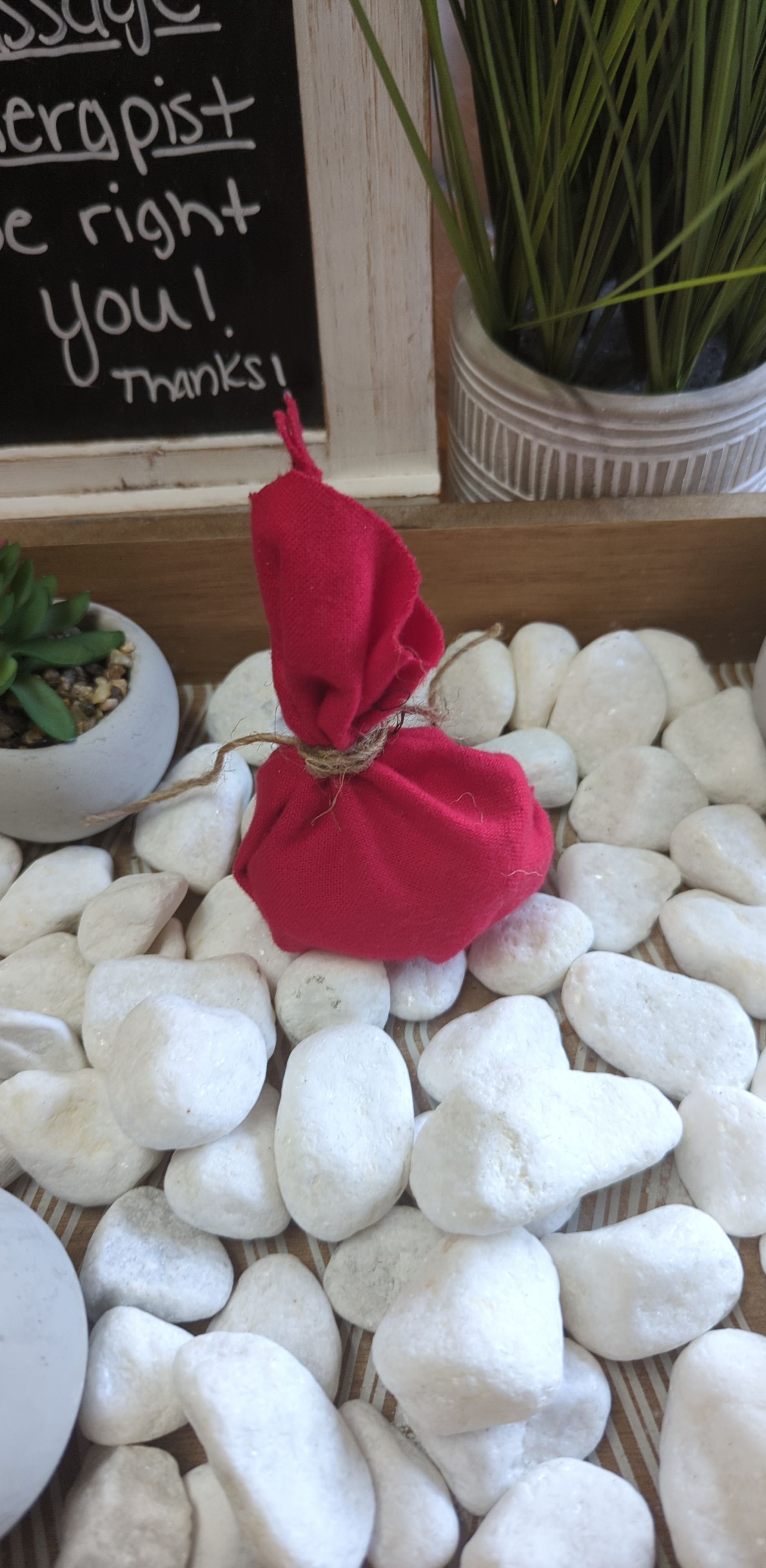 Red Love Drawing Mojo Bag on white stones, enhances love energy.