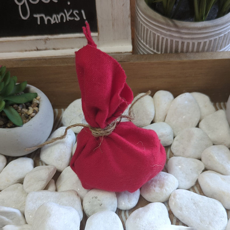 Red drawstring Love Drawing Mojo Bag with magical ingredients for love spells.