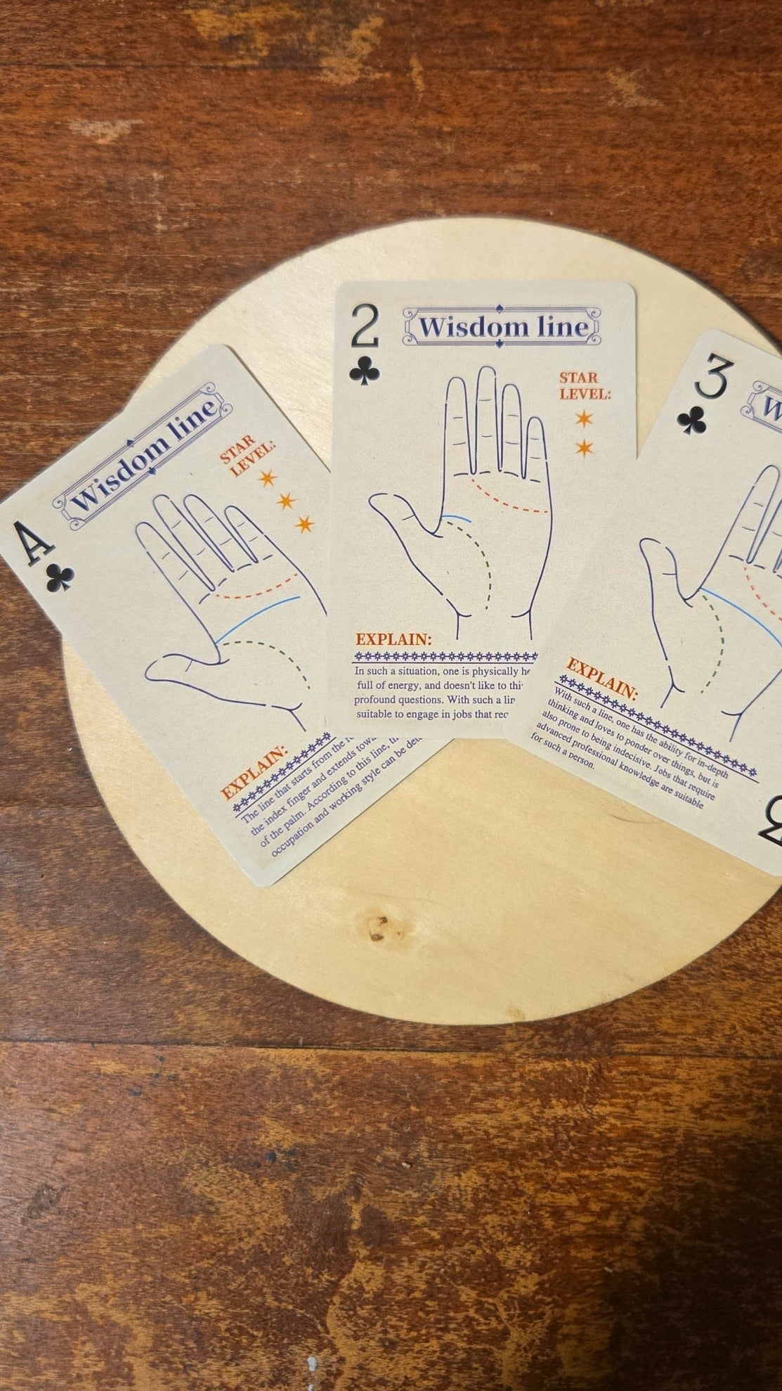 Wooden circular object with palm reading cards on a wooden surface